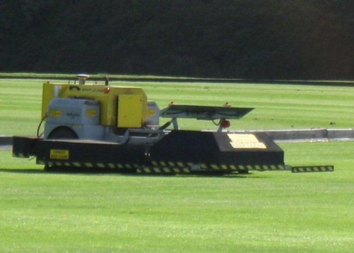Lawn mower maintenance after large property mowing Lawn mower equipment on grass with maintenance and after-cut inspection context
