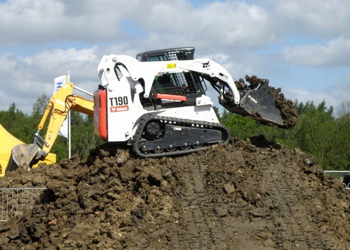 Skid steer loader material handling scene Skid steer loader positioned for compact material handling and site cleanup work