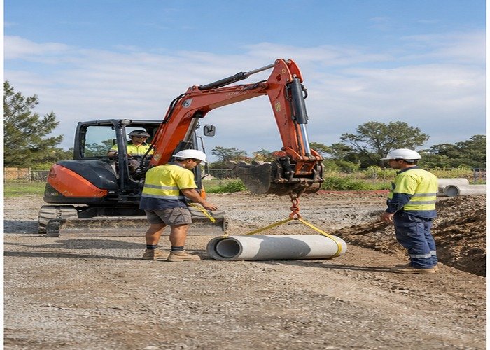 Operator and signaler checking pipe rigging and the exclusion zone Operator and signaler checking pipe rigging and the exclusion zone