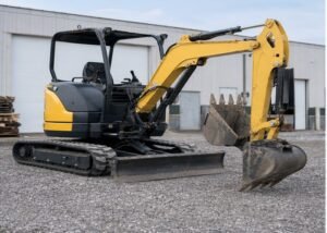 Mini excavator parked on gravel with rubber tracks visible