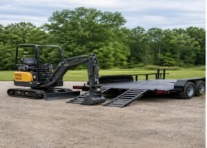 Mini excavator parked beside a trailer with ramps lowered for transport planning