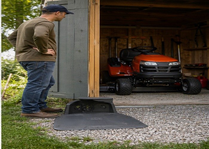 Property owner comparing robot mower charging dock and riding mower storage Property owner comparing robot mower charging dock and riding mower storage