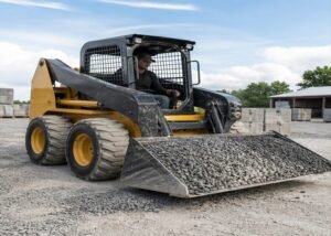 Wheeled skid steer moving gravel on a firm yard surface