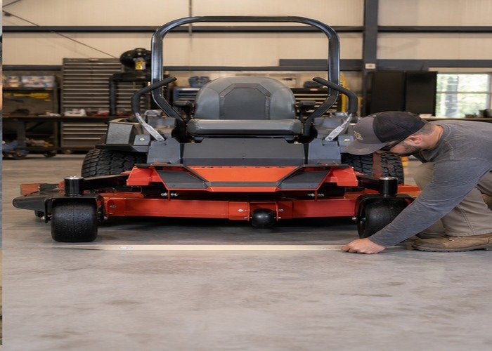 Operator checking deck level and tire stance on a flat shop floor Operator checking deck level and tire stance on a flat shop floor