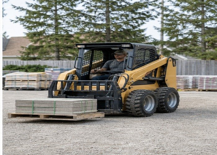 Compact skid steer carrying a low pallet on firm level ground Compact skid steer carrying a low pallet on firm level ground