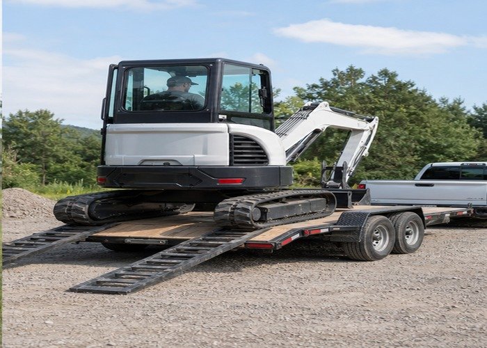 Mini excavator aligned on an equipment trailer after a job