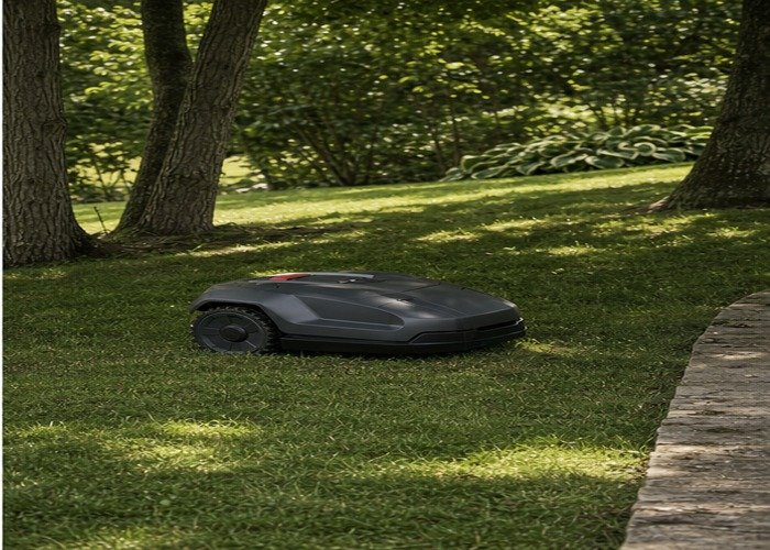 Robotic mower navigating a shaded uneven lawn near trees Robotic mower navigating a shaded uneven lawn near trees