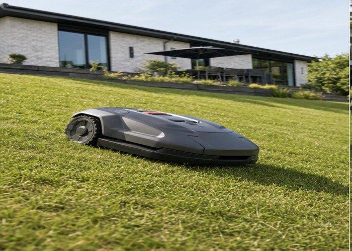 All-wheel-drive robotic lawn mower traversing a moderate dry lawn slope