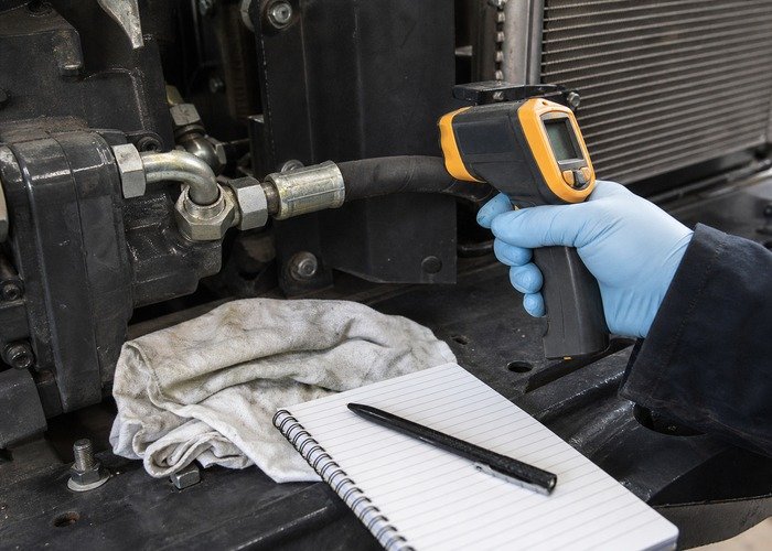 Checking compact tractor hydraulic hose temperature with an infrared thermometer