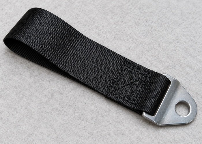 Illustrative detached restraint webbing sample and mounting end on inspection tray
