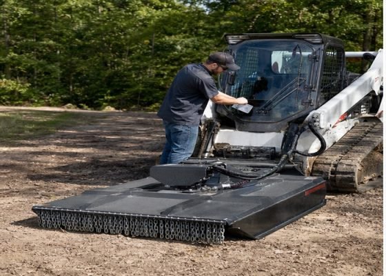 Skid steer with brush cutter attachment parked for hydraulic requirement checks