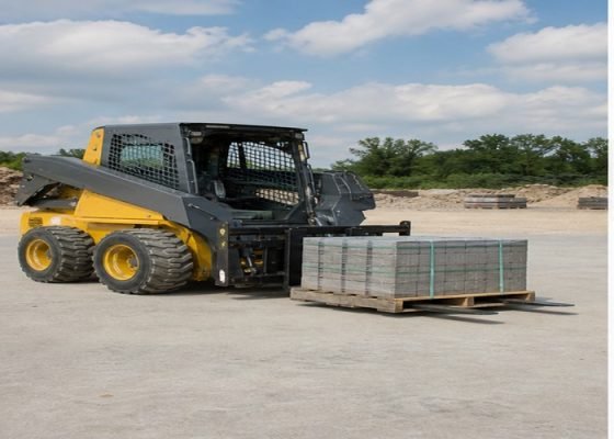 Skid steer carrying a centered pallet low on level concrete